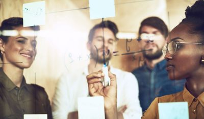 Researchers work on equation on clear board