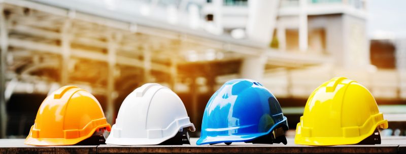 Multicolored construction helmets sitting on a table at a construction site